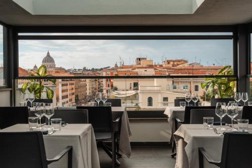 un restaurante con mesas y sillas y vistas a la ciudad en Twentyone Hotel, en Roma
