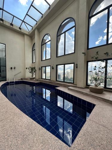 una piscina con piastrelle blu in un edificio con finestre di Clarion Faria Lima a San Paolo