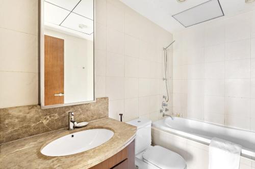 uma casa de banho com um lavatório, um WC e um espelho. em Silkhaus spacious 1BDR in Downtown at Standpoint em Dubai