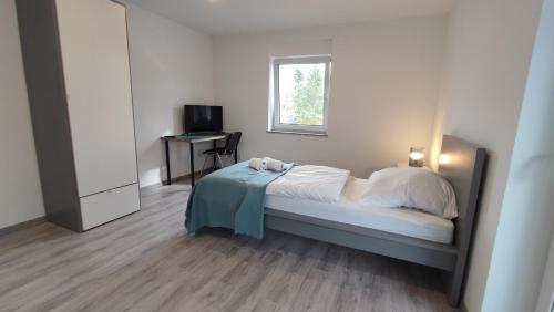 Un dormitorio con una cama con una mesa y una ventana. en Dammstraße 24-OG-ZV38, en Salzgitter