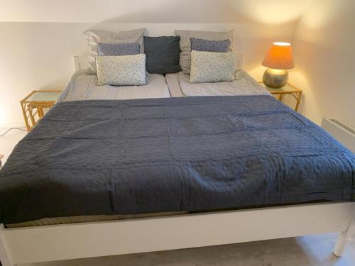 a large bed with a blue blanket and pillows at Bed & Breakfast “Den Gamle Lade I Hejls” in Hejls