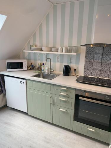 a kitchen with a sink and a stove at Bed & Breakfast “Den Gamle Lade I Hejls” in Hejls