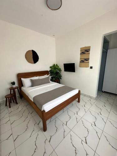 a bedroom with a bed in a white room at Coalescence Hotel Rwanda in Kigali