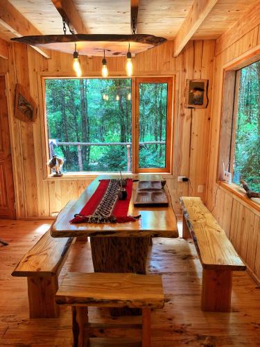 a large wooden table in a cabin with a keyboard at Casa Encantada HuiloHuilo in Puerto Fuy