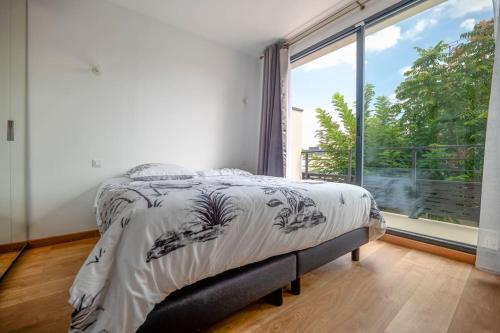 - une chambre avec un lit et une grande fenêtre dans l'établissement Maison équipée proche Paris, à Saint-Ouen