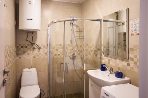 a bathroom with a shower and a toilet and a sink at Hotel Bratislava in Shekhvetili