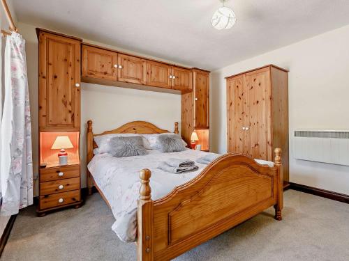 a bedroom with a large wooden bed and wooden cabinets at 3 Bed in Falmouth CONSW in Constantine