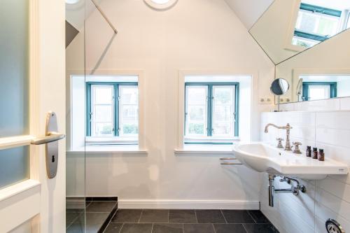 bagno bianco con lavandino e doccia di Huus Trift Whg 28b a Westerland