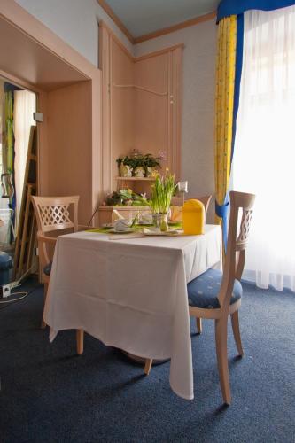 a dining room table with a white tablecloth and chairs at Hotel Scaletta in Pula