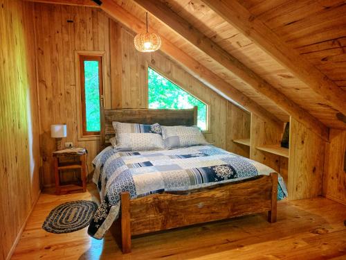 a bedroom with a bed in a log cabin at Casa Encantada HuiloHuilo in Puerto Fuy