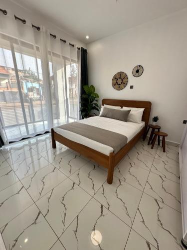 a bedroom with a bed on a marble floor at Coalescence Hotel Rwanda in Kigali