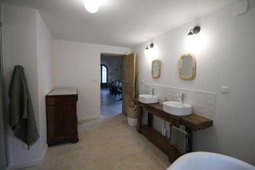 ein Badezimmer mit zwei Waschbecken und zwei Spiegeln an der Wand in der Unterkunft La Maison Bois Carré in Saint-Yzans-de-Médoc
