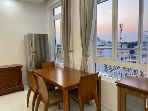 uma cozinha com uma mesa de madeira e um frigorífico em Paris Hotel Châu Đốc em Chau Doc