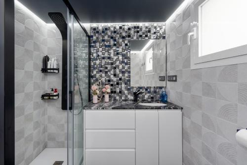 a bathroom with a sink and a glass shower at Urbanización jardines del mar in Castillo de Sabinillas