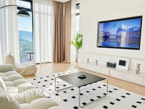 een woonkamer met een witte bank en een tv bij The Beacon Executive @Penang Georgetown in George Town