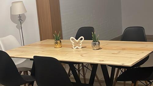une table en bois avec des chaises et une figurine de lapin sur celle-ci dans l'établissement Glass Student-Übica2 Guesthouse, à Mairena del Aljarafe