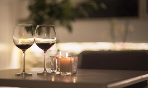 two glasses of wine and a candle on a table at Residenza Amblingh in Vasto