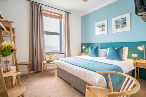 a bedroom with a large bed and a desk at Tregarthen's Hotel in Hugh Town