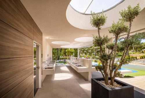 a bathroom with sinks and trees in a building at Maistra Camping Veštar Pitches in Rovinj