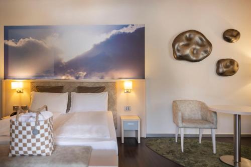 a hotel room with a bed and a table at Blu Hotel Natura & Spa - Adults Only in Folgaria