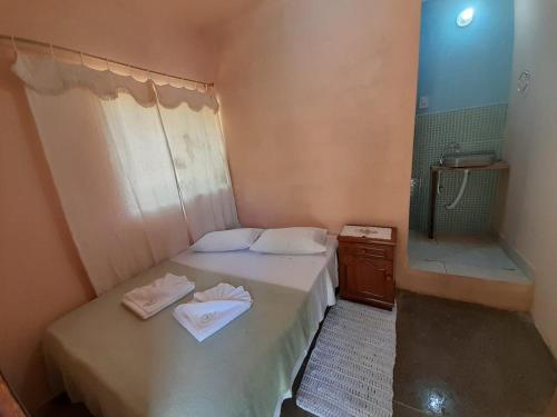 Dormitorio pequeño con cama y lavamanos en Espaço Bella Ville en Alto Caparao