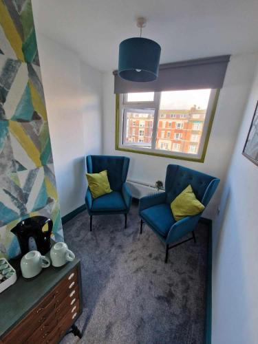 two blue chairs in a room with a window at The Coastal Hideaway in Bridlington