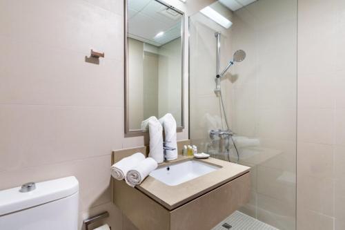 uma casa de banho com um lavatório e um chuveiro em Silkhaus stunning studio in central DIFC with balcony em Dubai