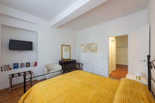 - une chambre avec un lit jaune et une télévision dans l'établissement Ciompi Square-Hosted by Sweetstay, à Florence