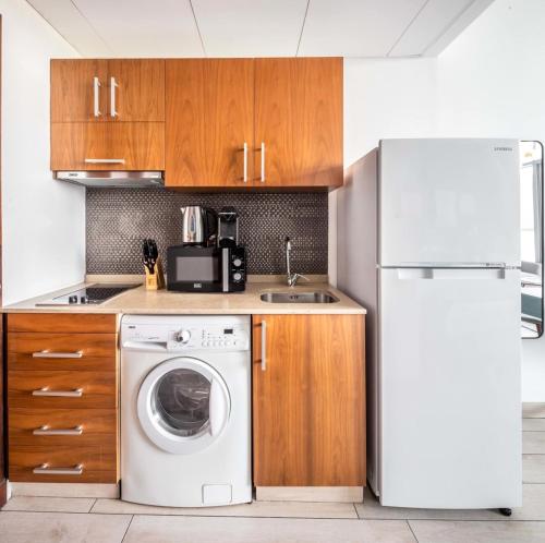 a kitchen with a washing machine and a refrigerator at Silkhaus elegant studio with Burj Khalifa view and balcony in Dubai