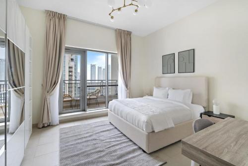 ein weißes Schlafzimmer mit einem Bett und einem Balkon in der Unterkunft Silkhaus with full Burj Khalifa & fountain view 1BDR in Downtown in Dubai