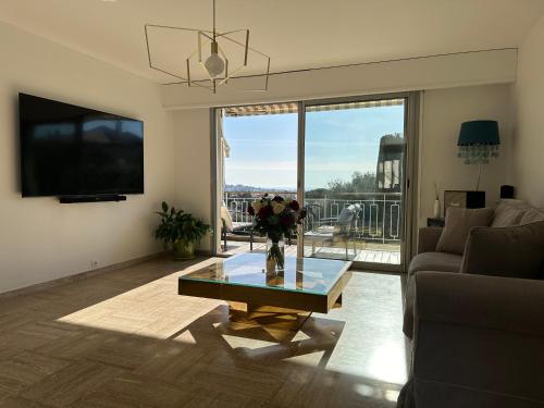 un salon avec un vase de fleurs sur une table dans l'établissement The Place *****, à Cannes