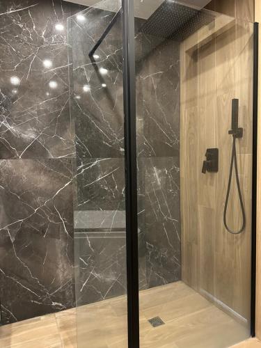 une douche avec une porte vitrée dans une salle de bain dans l'établissement The Place *****, à Cannes