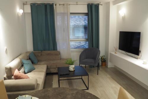 - un salon avec un canapé et une télévision dans l'établissement Moderno apartamento con garaje privado en el centro de Vigo, à Vigo