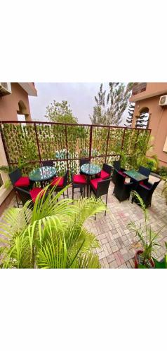 a patio with tables and chairs and plants at Hotel Fountain Blu in Abeokuta
