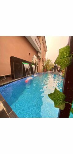 a swimming pool with green plants on top of it at Hotel Fountain Blu in Abeokuta