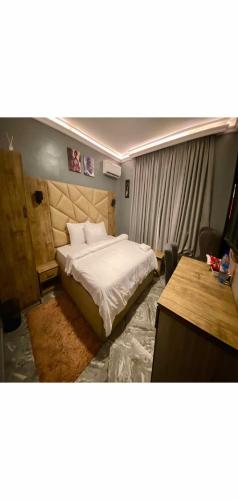a bedroom with a large bed and a desk at Hotel Fountain Blu in Abeokuta