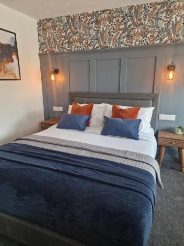 a bedroom with a large bed with blue and orange pillows at The Coastal Hideaway in Bridlington