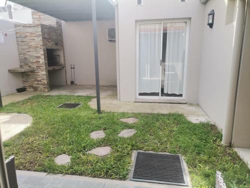 un patio con césped y piedras frente a una puerta en MANDALA HOME en Durazno