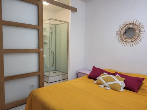 sypialnia z łóżkiem i przeszklonym prysznicem w obiekcie Abrivado Appartements meublés dans une grande propriété en rez de jardin w mieście Aimargues