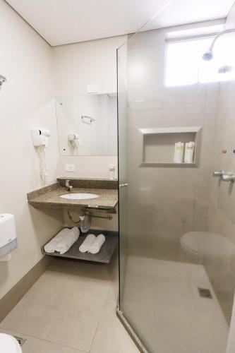 a bathroom with a shower and a sink at Tonello Business Hotel in Campo Mourão