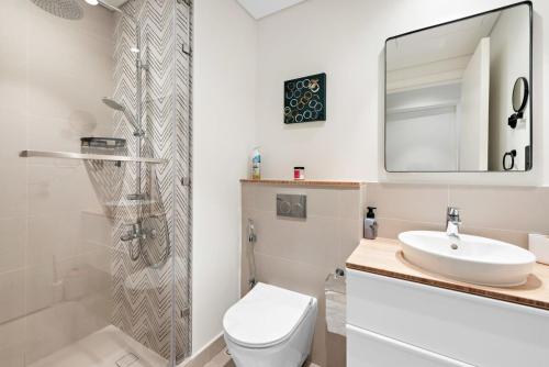 bagno con lavandino, servizi igienici e specchio di Silkhaus Luxury 1BDR Dubai Hills Pool & Gym a Dubai