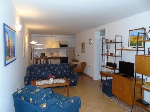 ein Wohnzimmer mit einem blauen Sofa und einem Tisch in der Unterkunft Apartments Sonja in Opatija