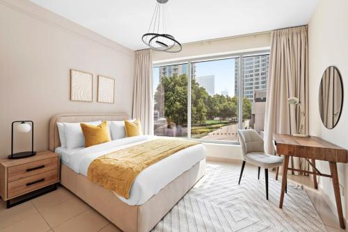 een slaapkamer met een bed, een bureau en een raam bij Silkhaus Modern 1BDR in Marina Close to Beach in Dubai