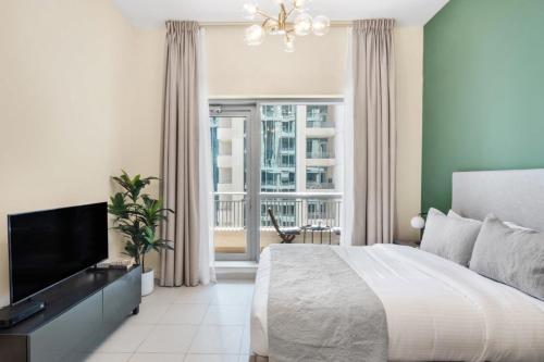 een slaapkamer met een bed en een flatscreen-tv bij Silkhaus lovely studio with Downtown view in Boulevard central in Dubai