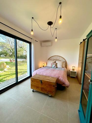 a bedroom with a bed and a large window at Maison à la campagne 4 personnes in Montauroux