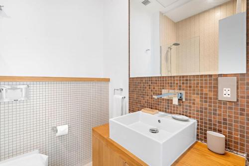 een badkamer met een witte wastafel en een spiegel bij Silkhaus cozy Studio at Al Bandar Marina with gym in Abu Dhabi