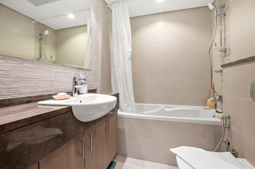 Silkhaus Luxury studio in Saadiyat Island في أبوظبي: حمام مع حوض وحوض استحمام
