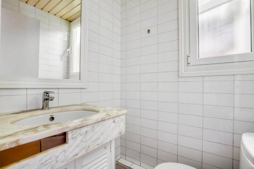 a white bathroom with a sink and a toilet at Blueground Pedralbes balcony swimming pool BCN-124 in Barcelona