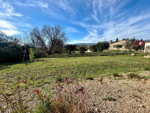 a field of grass with flowers in the foreground at Maison à la campagne 4 personnes in Montauroux