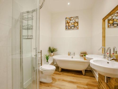 a bathroom with two sinks and a tub and a toilet at 2 Bed in Westward Ho 89540 in Bideford